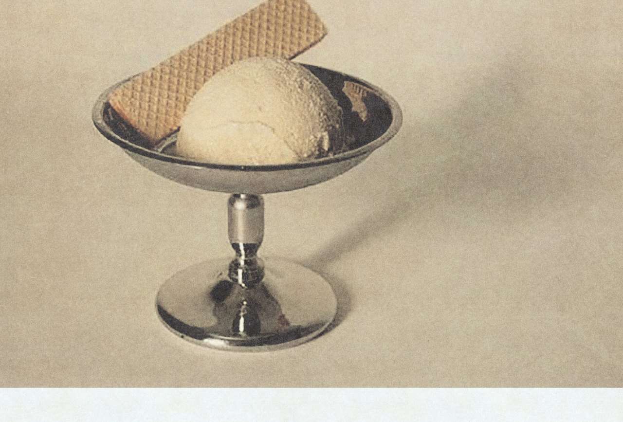 A scoop of BATCH ice cream in a metal coupe with a wafer